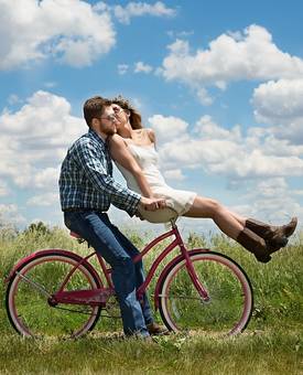 Een man en een vrouw samen op een fiets
