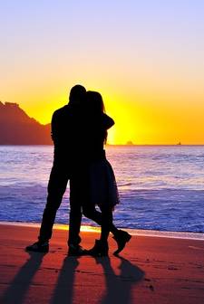 Een stel op het strand met een zonsondergang